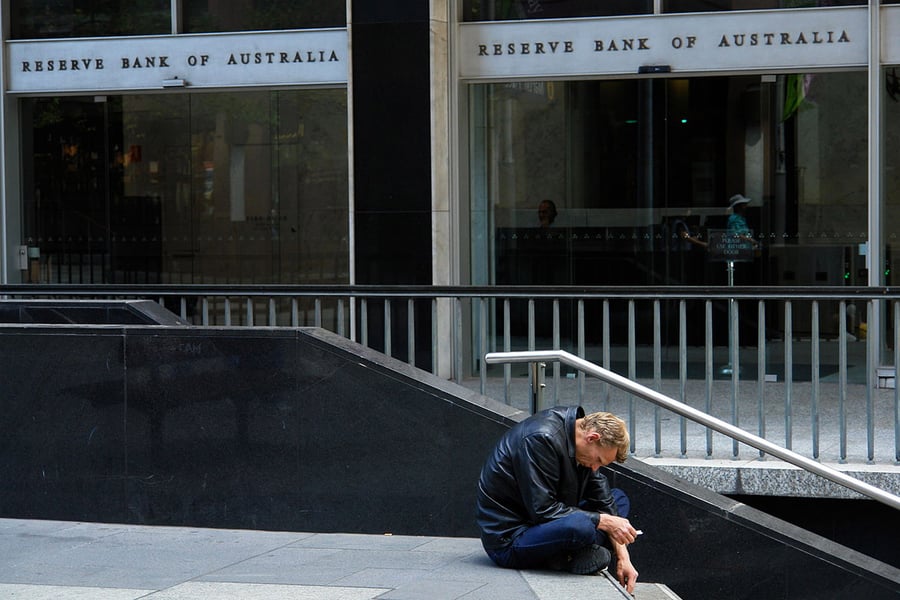 Image of a man sitting outside the Reserve Bank of Australia