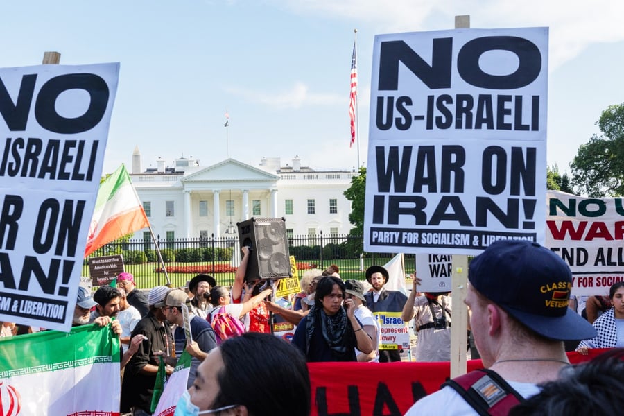 Demonstrators holding signs that read "No US-Israel War on Iran" join a protest in front of the White House