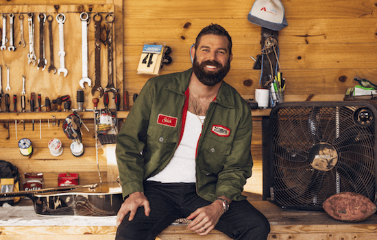 Jordan Davis posing in a shed smiling at the camera