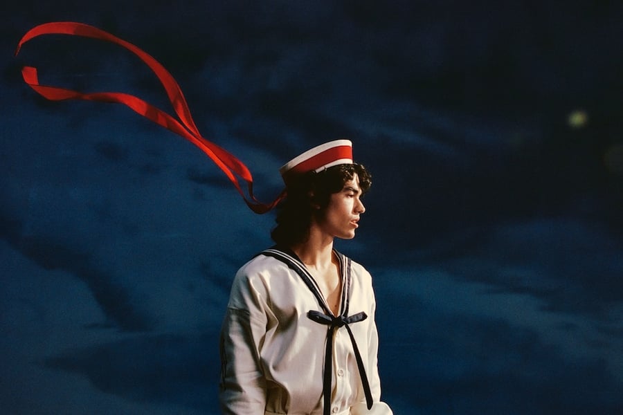 Conan Gray in a sailor outfit with a red ribbon