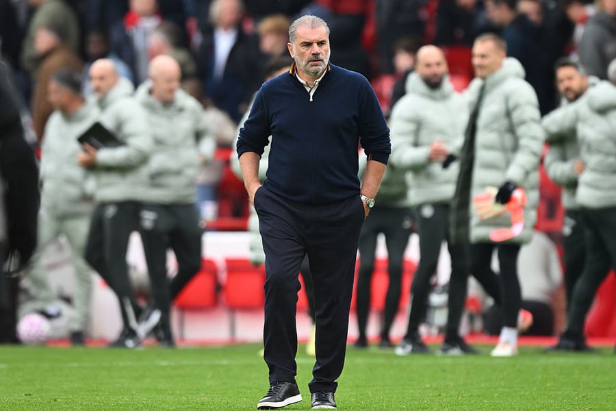 Ange Postecoglou walks across a football pitch