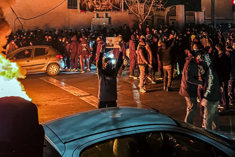 Iranians gather while blocking a street during a protest in Tehran