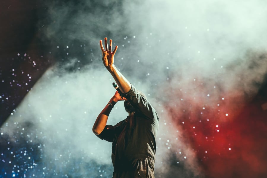 Pop artist performing on stage under neon lights